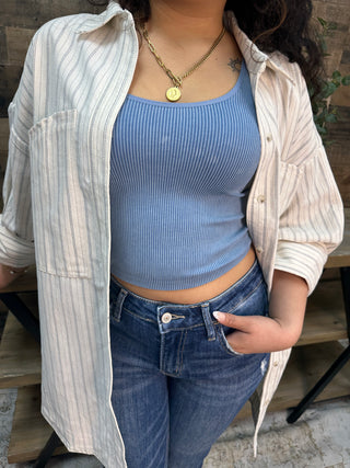 Ivory and black striped button-down shirt worn open over blue ribbed crop top.
