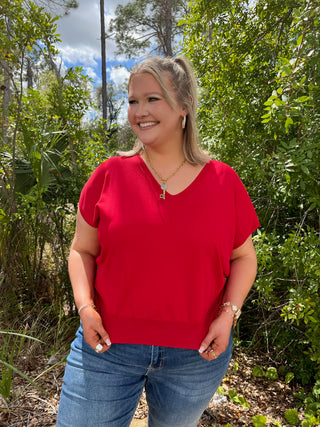 Red v-neck short sleeve knit top with relaxed fit styling.
