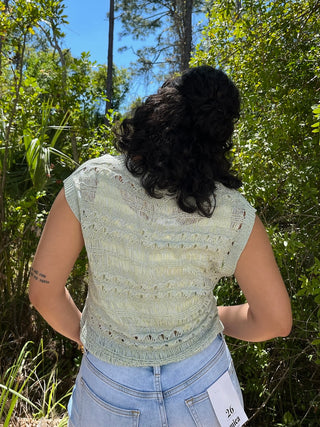 Cream crochet sleeveless top with textured pattern and shell stitch detail.
