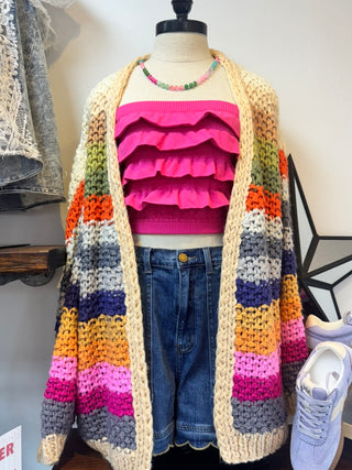 Fuchsia ruffle bandeau top paired with colorful striped cardigan and denim shorts.
