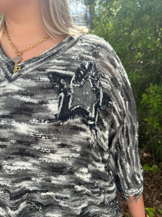 Charcoal and white slub knit top with distressed black star patch and frayed edges on short sleeve.
