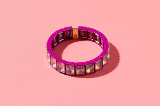 Magenta stretch bracelet with square iridescent crystal stones and gold accents.
