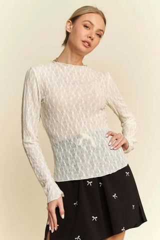 Cream embroidered long sleeve layer top on a mannequin, showcasing intricate details and soft fabric, perfect for elegant layering.