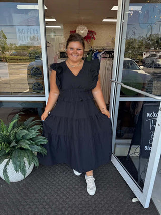 Umgee Black V Neck Ruffle Midi Dress on hanger, showcasing elegant design, lightweight fabric, and stylish ruffle details