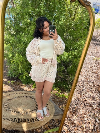 Cream lace shorts with ruffled hem and matching lace cardigan, paired with white crop top.
