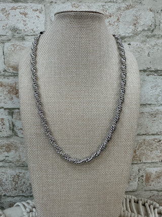 Silver braided twisted link chain necklace displayed on cream linen bust form.
