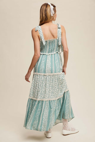 Alt text: "Listicle Maxi Dress in Sage Floral with Smock Tiered Ruffle design displayed on a mannequin.