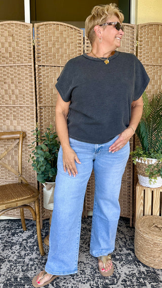 Navy blue oversized drop shoulder t-shirt with rolled sleeves, paired with light blue jeans.
