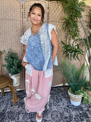 Blush pink ribbed joggers with white lace appliqué details and drawstring waist.
