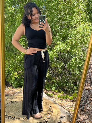 Black wide-leg pants with textured swirl pattern and cream drawstring waist paired with black crop tank.
