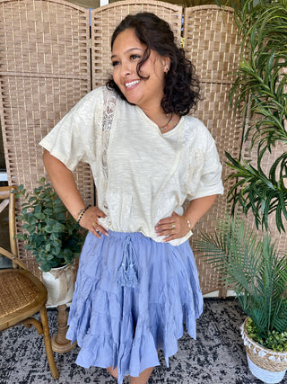 Cream patchwork lace short-sleeve top paired with periwinkle tiered ruffle skirt.
