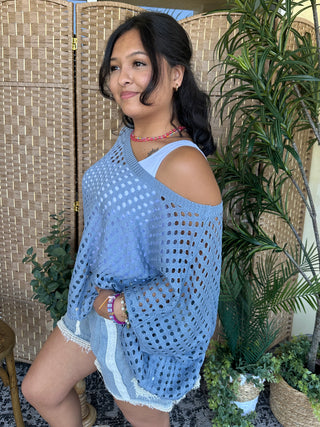 Blue knit dolman top with eyelet pattern and cutout shoulder detail.
