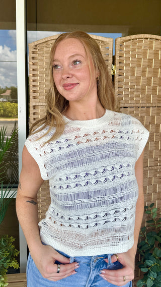Ivory crochet sleeveless top with open knit pattern and textured stripes.
