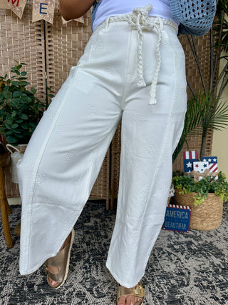 White gypsy fit pants with embroidered floral details and cream rope drawstring waist.
