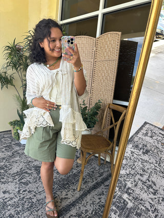 Cream striped kimono top with ruffled lace hem and tie-front closure.
