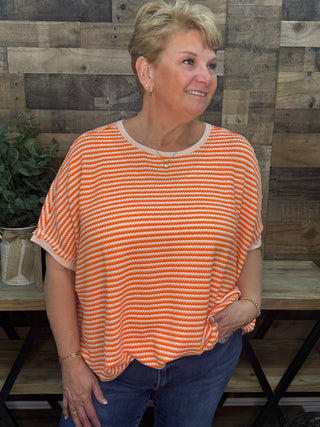 Orange and white striped short sleeve tee with crew neckline and relaxed fit.
