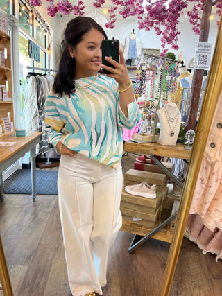 Ocean blue and cream striped batwing top with cream pants, worn in boutique mirror selfie.
