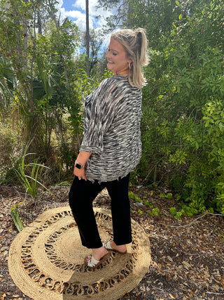 Charcoal and white zebra stripe short sleeve top with textured slub fabric worn with black pants.
