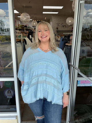 Light Blue Mix Fabric V Neck Oversized Top by Oli & Hali displayed on a hanger against a gray background.