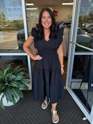 Alt text: "Umgee black V-neck ruffle midi dress on display, showcasing elegant style and flowy silhouette.