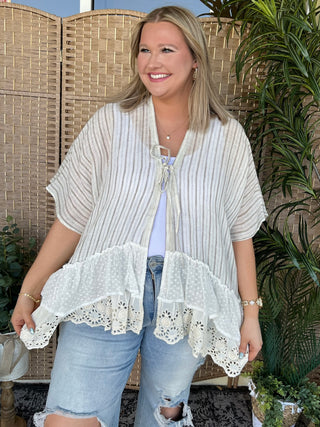 Cream striped kimono with white eyelet ruffled hem and tie front closure.
