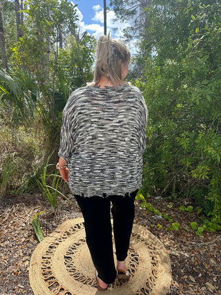 Charcoal and white striped short-sleeve top with distressed hem, worn with black leggings.
