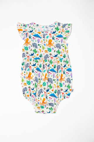 Colorful infant bubble romper with ocean creatures and seaweed print on white background.
