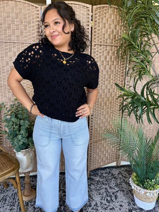 Black open weave short-sleeve sweater top with textured knit pattern and cutout details.
