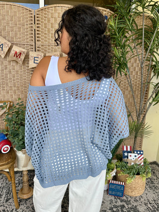 Light blue dolman top with geometric eyelet pattern and white trim, worn off-shoulder.
