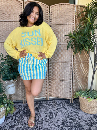 Yellow sweatshirt with blue Sun Kissed graphic and blue striped mini skort.
