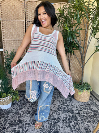 Pastel striped sleeveless tank top with pink sharkbite hem in white, blue and pink stripes.
