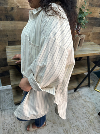 Ivory button-down top with black vertical stripes, relaxed fit, shown from back view on model.
