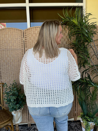 White openwork dolman top with short sleeves and textured knit pattern.
