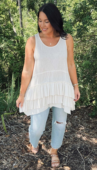 Ivory sleeveless tunic top with tiered ruffle hem by Sew In Love, displayed on a hanger against a neutral background.