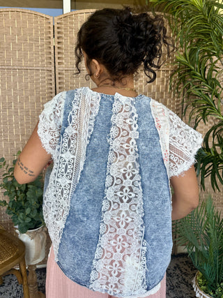 Blue denim and white lace patchwork top with short sleeves and curved hem.