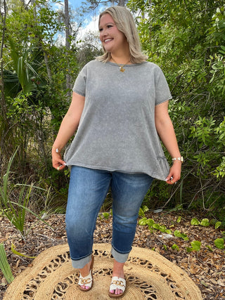 Charcoal gray short-sleeve tee with ruffle hem and chest detail, relaxed fit.
