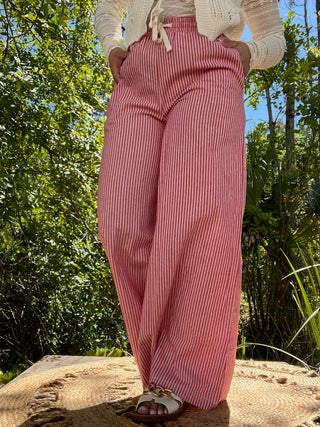 Red vertical striped wide leg pants with elastic waist paired with cream cardigan.

