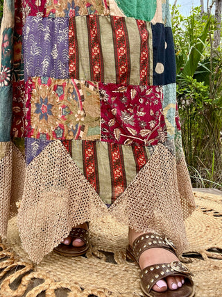 Boho patchwork maxi skirt with burgundy floral, purple geometric, tan striped, and cream crochet panels.
