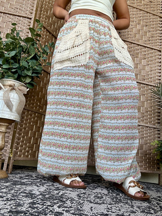 Aqua and peach striped knit pants with textured detail, worn with white crop top and brown slides.
