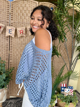 Light blue dolman top with eyelet cutout pattern and cold shoulder design.
