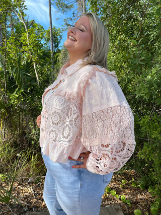 Blush lace shacket with button front and delicate floral cutout details.

