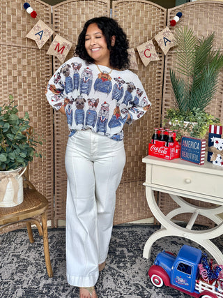 White batwing top with blue striped and floral print pattern paired with white jeans.

