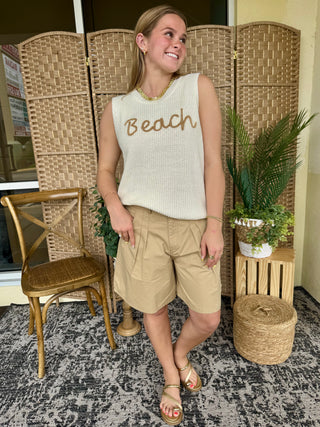 Cream ribbed sleeveless tank top with "Beach" embroidered in tan text.
