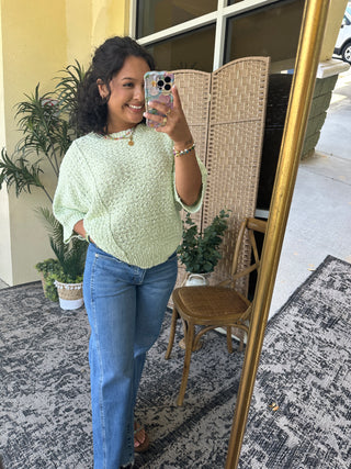 Mint green speckled crew neck sweater with asymmetrical hem paired with classic blue jeans.
