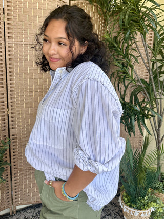 Light blue and white pinstripe oversized button-up shirt with ruched sleeves.
