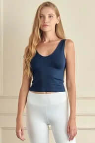 Navy seamless tank top, buttery soft and reversible, displayed on a hanger against a light gray background.