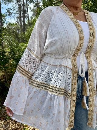 Ivory parasail shell kimono with lace trim, tassel tie, and beige macramé trim details.
