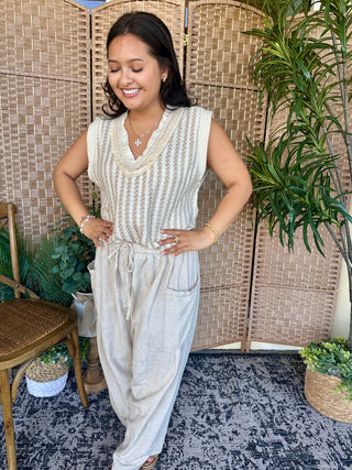 Cream striped sleeveless tank top with V-neckline and drawstring waist on model.

