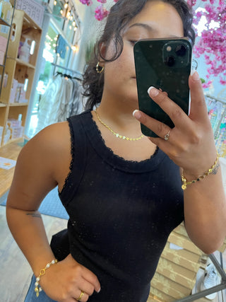Black ribbed knit tank top with lettuce edge neckline and sleeves.
