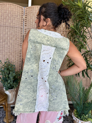 Oversized olive green tank top with white lace center stripe and eyelet detailing, worn with pink pants.